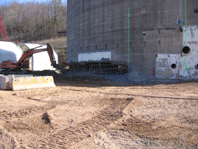 An excavator-cutter removing the concrete exterior of the containment building's outer wall